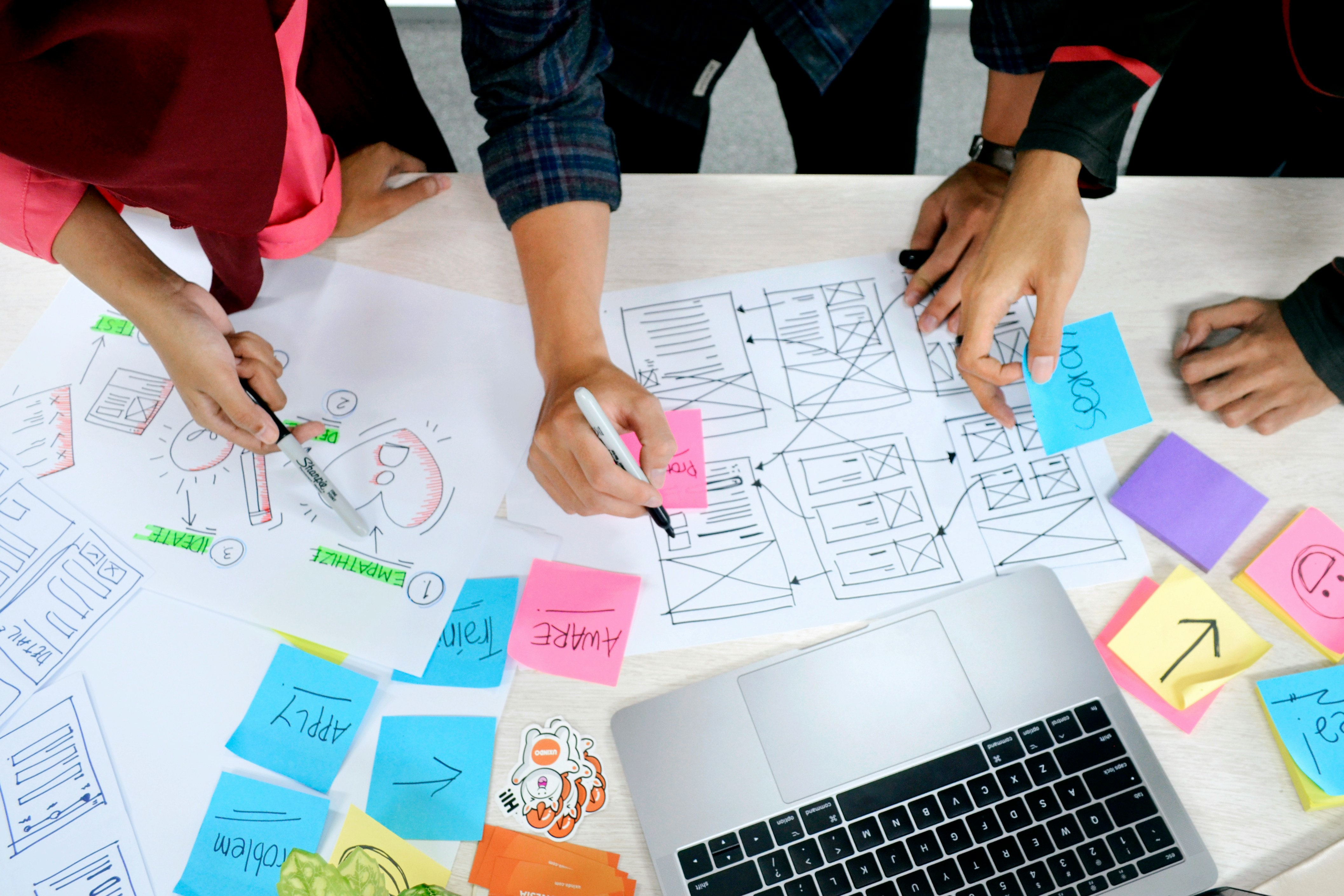 Team planning website wireframes at a desk