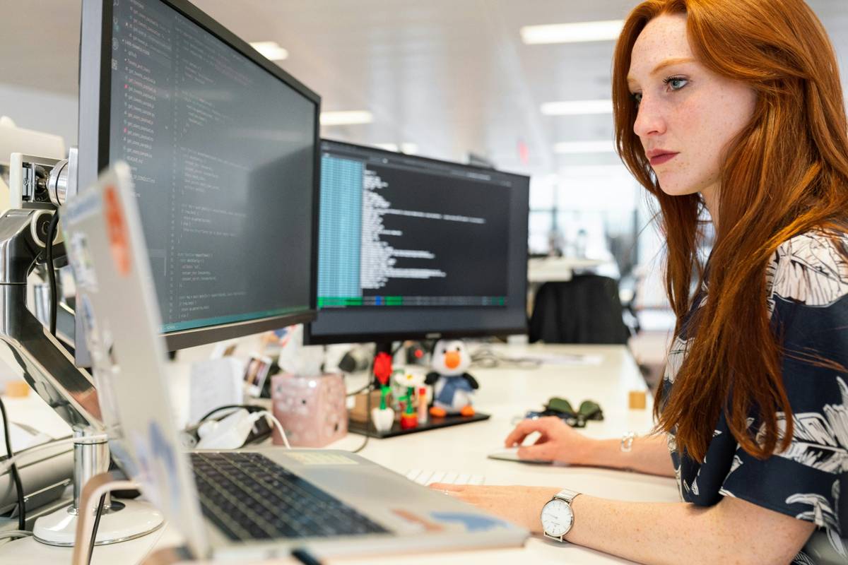 Developer working at dual monitors in a modern office